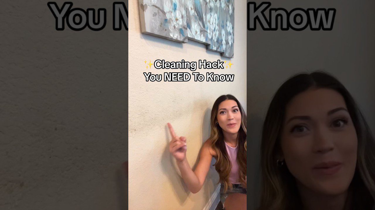 Moteris rodo į sieną su užrašu „Cleaning Hack You NEED To Know“ ir tapyba viršuje