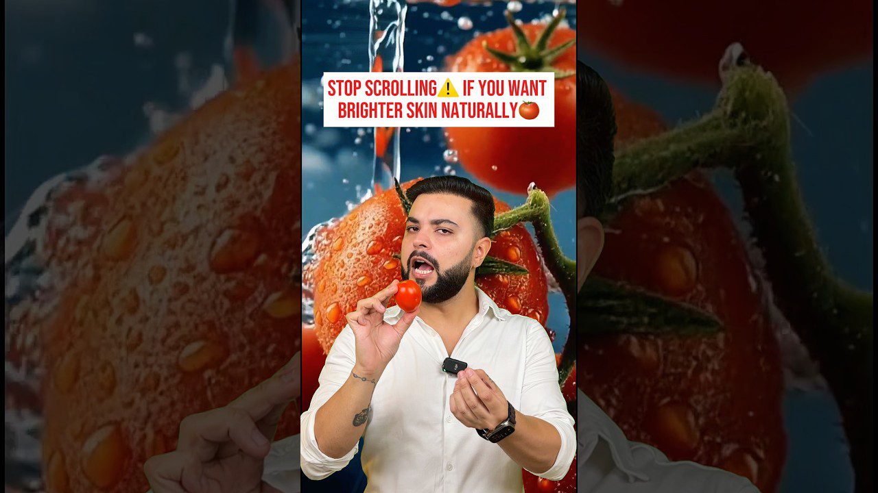 Vyras laiko mažą pomidorą prie burnos, fone dideli vandeniu aplieti pomidorai