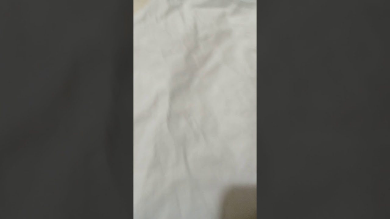 Balta raukšlėta patalynė su švelniu šešėliu apatiniame dešiniajame kampe
