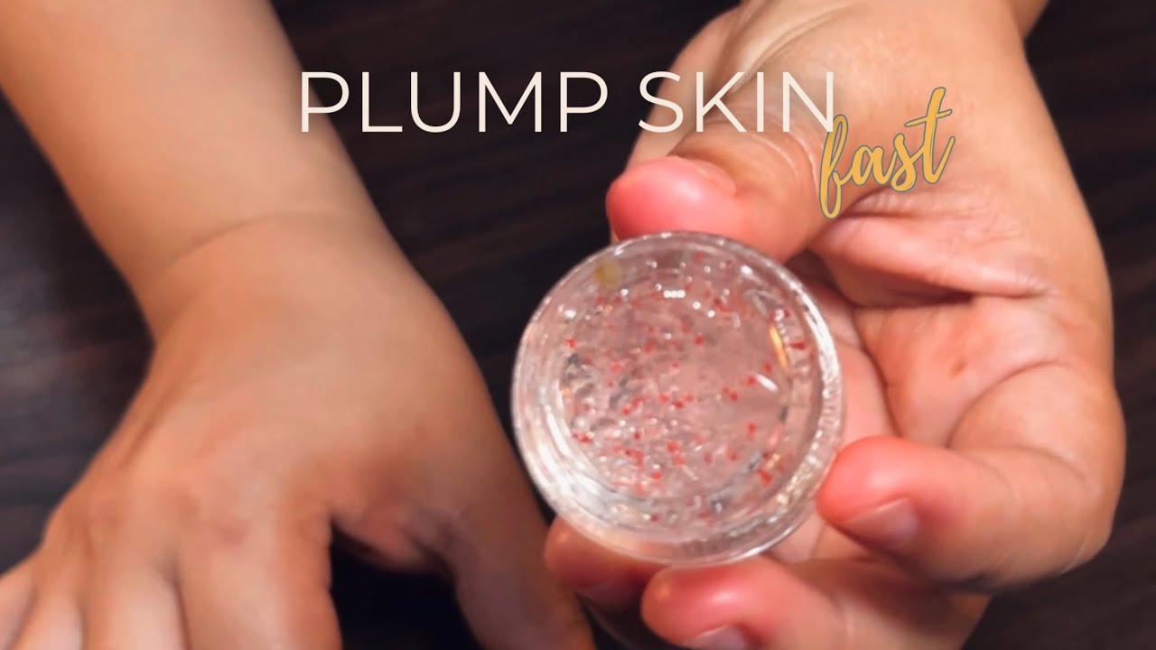 Rankoje laikomas mažas indelis su blizgiu geliu, fone užrašas „Plump Skin fast“.